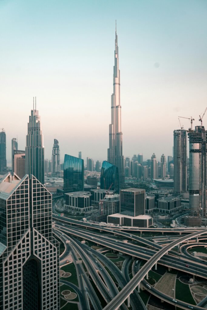 pexels photo 3214995 3214995 Aerial view of Dubai's skyline with Burj Khalifa and intricate highway system at sunset.